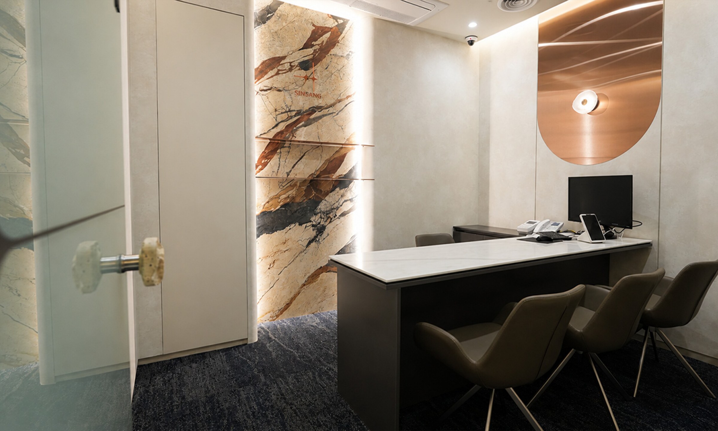 Consultation room with marble-paneled walls and a desk
